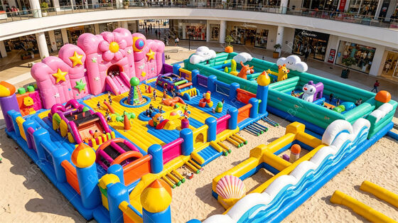 Cidade de diversão inflável com tema de pastel gigante. Parque de salto todo-em-um com escorrega de flores, zonas de brinquedo de animais e obstáculos interativos. PVC comercial para shoppings e festivais ao ar livre.