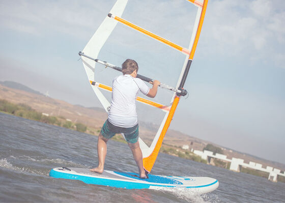 O fanático levanta-se a carga inflável da placa 150kg do SUP da vela